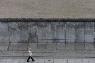 A man walks along the former border separating West and East Germany (GDR) in the German capital on November 5, 2014 at the Berlin Wall Memorial in the Bernauer Strasse. Germany will organize a giant party on November 9, 2014 to commemorate the 25th anniversary of the Berlin Wall Fall. AFP PHOTO / TOBIAS SCHWARZ<!-- NICAID(10964407) -->