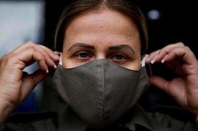 PORTO ALEGRE, RS, BRASIL, 27-04-2020: A soldado Carina Espíndola, 40 anos, veste máscara doada para os policiais militares. Grupo de costureiras voluntárias, liderado pela designer de moda e costureira Sandra da Costa Colares, realizou a entrega solidária no Hospital da Brigada Militar. (Foto: Mateus Bruxel / Agência RBS)<!-- NICAID(14486606) -->