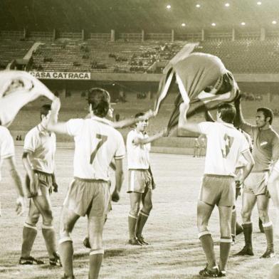 Você talvez não saiba, mas esta é a segunda vez em 35 anos que o Beira-Rio é requisitado para um jogo decisivo da Copa Libertadores da América. A primeira foi dia 28 de abril de 1970. Pouco mais de um ano depois do festival de inauguração, o estádio sediou a partida de desempate entre o Universidad, do Chile, e o Nacional, de Montevidéu, por uma vaga na semifinal da competição (na época, em caso de vitória para cada time, o desempate era sempre em local neutro). Poucos torcedores viram o jogo, o que certamente não ocorrerá esta noite. Sabem quem era o goleiro do time uruguaio, que na foto faz a saudação à torcida? Ele mesmo, Manga, o Manguita Fenômeno, que a partir de 1974, no embalo de grandes defesas, se tornaria um dos maiores ídolos do Inter.#PÁGINA:53 Fotógrafo: BD ZH<!-- NICAID(1686763) -->