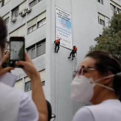  PORTO ALEGRE, RS, BRASIL, 29-04-2020: Alpinistas escalam o hospital São Lucas, da Pucrs, e estendem faixa para homenagear profissionais da saúde, que atuam na linha de frente no combate à pandemia de covid-19. (Foto: Mateus Bruxel / Agência RBS)Indexador: Mateus Bruxel<!-- NICAID(14488335) -->