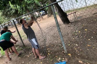 Após depredação, frequentadores do cachorródromo da praça Brigadeiro Sampaio consertam tela rasgada.<!-- NICAID(14489378) -->