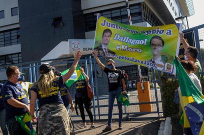 Supporters of the ex-Brazilian Minister of Justice and Public Security, Sergio Moro (R) and supporters of Brazil President Jair Bolsonaro (L) argue in front of the Federal Police headquarters where Moro is expected to testify about his accusation against Bolsonaro that he was trying to intervene investigations of the Brazil Federal Police, in Curitiba, Parana State, Brazil, on May 2, 2020. - Brazilian supreme court Celso de Mello gave the federal police on April 27, 2020 60 days to question Moro about his explosive allegations that Bolsonaro sought to interfere with police investigations. The findings could result in either a request for political trial against Bolsonaro or an indictment against Moro for false testimony. (Photo by Franklin FREITAS / AFP)<!-- NICAID(14490959) -->