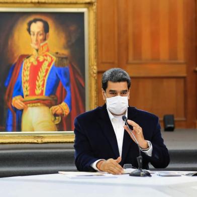  Handout picture released by the Venezuelan Presidency showing Venezuelas President Nicolas Maduro wearing a face mask as a preventive measure against the novel coronavirus, COVID-19, during a meeting with members of the Bolivarian National Armed Forces (FANB), at Miraflores Presidential Palace in Caracas on May 4, 2020. - Venezuelas Attorney General Tarek William Saab on Monday accused opposition leader Juan Guaido of contracting mercenaries to lead an invasion that the Nicolas Maduro regime claims to have thwarted. The government had said Sunday that it foiled an attack from the sea aimed at toppling the socialist president, killing eight assailants and capturing two others. (Photo by Jhonn ZERPA / Venezuelan Presidency / AFP) / RESTRICTED TO EDITORIAL USE - MANDATORY CREDIT AFP PHOTO / VENEZUELAS PRESIDENCY / JHONN ZERPA - NO MARKETING - NO ADVERTISING CAMPAIGNS - DISTRIBUTED AS A SERVICE TO CLIENTSEditoria: POLLocal: CaracasIndexador: JHONN ZERPASecao: armed ForcesFonte: Venezuelan PresidencyFotógrafo: Handout<!-- NICAID(14492817) -->