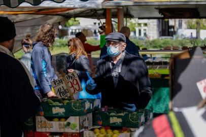 (FILES) In this file photo taken on April 17, 2020 a man wearing a protective face mask shops at a fruit and vegetable market in Berlin, amid the novel coronavirus COVID-19 pandemic. - In Germany, fresh food prices were up nearly 10 percent in April compared with a year earlier, according to agriculture markets consultancy AMI. (Photo by David GANNON / AFP)<!-- NICAID(14493427) -->