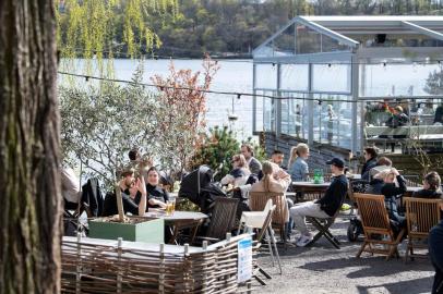  People sit in the spring sun at an outdoor restaurant in Stockholm, Sweden on April 26, 2020, amid the novel coronavirus COVID-19 pandemic. - Stockholm health inspectors said on April 26, 2020 they ordered five bars and restaurants shuttered after they failed weekend inspections to ensure social distancing regulations were being observed to curb the spread of the new coronavirus. (Photo by Jessica GOW / various sources / AFP) / Sweden OUTEditoria: HTHLocal: StockholmIndexador: JESSICA GOWSecao: epidemic and plagueFonte: TT News AgencyFotógrafo: STF<!-- NICAID(14493858) -->