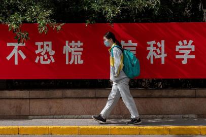  A student wearing a face mask amid concerns of the COVID-19 coronavirus passes by a propaganda poster on a street that reads "No Panic Trust Science" as she leaves a middle school in Beijing on May 11, 2020. - Students in a number of cities including Shanghai and Beijing began returning to classes in late April, starting with high schoolers. (Photo by NICOLAS ASFOURI / AFP)Editoria: HTHLocal: BeijingIndexador: NICOLAS ASFOURISecao: healthcare policyFonte: AFPFotógrafo: STF<!-- NICAID(14497091) -->