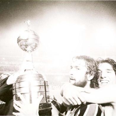 CRÉDITO: Adolfo Alves - Agência RBSA imagem acima, com ligeiras variações, aconteceu duas vezes em 1983.A primeira foi esta mesmo: De León ergue a taça da Libertadores no Olímpicoapós a vitória sobre o Peñarol, abraçado com alegria juvenil pelo herói RenatoPortaluppi. A outra viria meses depois, na final contra o Hamburgo, em Tóquio,quando o Grêmio esculpiu o nome na galeria dos campeões do mundo. A partirde hoje, quando o time do técnico Mano Menezes entrar em campo contra o Cerro Porteño, no Paraguai, gremistas do país inteiro têm todo o direito de sonhar com uma reprise de 1983. Pode ser que dê tudo errado, claro que pode, o futebol está cheio de casos assim. Mas o fato é que o Grêmio fez tudo certo para disputar a Libertadores com chances de ganhá-la. Manteve a comissão técnica, agregou experiência e qualidade ao grupo do ano passado e, o mais importante, colheu os frutos da reestruturação das categorias de base. Lucas, Carlos Eduardo e Everton estão aí. O Grêmio conquistou o direito de imaginar uma nova versão de si mesmo, quem sabe com Tcheco no lugar de De León, e Lucas, no de Renato.#PÁGINA:53<!-- NICAID(1921372) -->