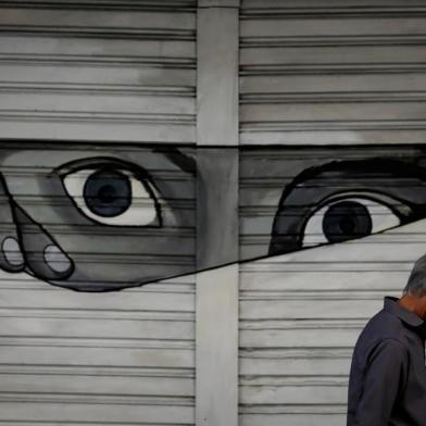  PORTO ALEGRE, RS, BRASIL, 20-04-2020, 13h: Pedestre com máscara no rosto caminha em frente a um grafite na avenida Borges de Medeiros, sob o viaduto Otávio Rocha. (Foto: Mateus Bruxel / Agência RBS)Indexador: Mateus Bruxel<!-- NICAID(14482074) -->