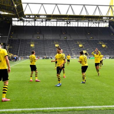 Dortmunds Norwegian forward Erling Braut Haaland (L) celebrates with team players after scoring the opening goal during the German first division Bundesliga football match BVB Borussia Dortmund v Schalke 04 on May 16, 2020 in Dortmund, western Germany as the season resumed following a two-month absence due to the novel coronavirus COVID-19 pandemic. (Photo by Martin Meissner / POOL / AFP) / DFL REGULATIONS PROHIBIT ANY USE OF PHOTOGRAPHS AS IMAGE SEQUENCES AND/OR QUASI-VIDEO<!-- NICAID(14501646) -->