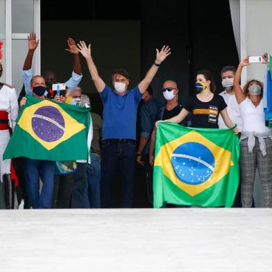  Brazilian President Jair Bolsonaro (C) waves to supporters duering a rally in Brasilia on May 17, 2020, amid the novel coronavirus pandemic. - Brazils COVID-19 death toll passed 15,000 on Saturday, official data showed, while its number of infections topped 230,000, making it the country with the fourth-highest number of cases in the world. (Photo by Sergio LIMA / AFP)Editoria: HTHLocal: BrasíliaIndexador: SERGIO LIMASecao: diseaseFonte: AFPFotógrafo: STR<!-- NICAID(14501847) -->