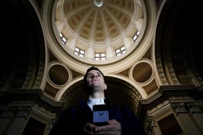  PORTO ALEGRE, RS, BRASIL, 18-05-2020: O padre Eduardo Kologeski dos Santos na Catedral Metropolitana com seu telefone. O sacerdote atende chamadas do serviço telefônico TelePaz, lançado pela igreja católica para qualquer pessoa em busca de um momento para expressar preocupações trazidas pela pandemia de covid-19 ou uma companhia para rezar. A iniciativa tem apoio e suporte técnico da Pucrs e funciona de segunda a domingo, das 9h às 12h, das 15h às 19h e das 20h às 23h, pelo número 3320-3800. (Foto: Mateus Bruxel / Agência RBS)Indexador: Mateus Bruxel<!-- NICAID(14502230) -->