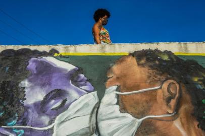  A woman wearing a face mask stands above a graffiti by artist Marcos Costa, or Spraycabuloso, at the entrance of the Solar de Unhao favela in Salvador on April 15, 2020. - Brazil, has registered 1,532 deaths from the new coronavirus so far. (Photo by ANTONELLO VENERI / AFP)Editoria: HTHLocal: SalvadorIndexador: ANTONELLO VENERISecao: diseaseFonte: AFPFotógrafo: STR<!-- NICAID(14478476) -->