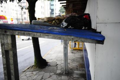  CAXIAS DO SUL, RS, BRASIL, 12/05/2020. FAS diz que houve redução de moradores de rua em Caxias do Sul. Em alguns pontos, realmente parece ter diminuído. Em outros pontos, pessoas seguem residindo nas calçadas e até mesmo sobre paradas de ônibus. Na foto, cama improvisada em cima de parada de ônibus na rua Marechal Floriano, quase na esquina com Pinheiro Machado. (Porthus Junior/Agência RBS)<!-- NICAID(14498206) -->