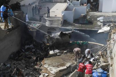  Police spray water on the part of a Pakistan International Airlines aircraft after it crashed at a residential area in Karachi on May 22, 2020. - A Pakistan passenger plane with more than 100 people believed to be on board crashed in the southern city of Karachi on May 22, the countrys aviation authority said. (Photo by Asif HASSAN / AFP)Editoria: DISLocal: KarachiIndexador: ASIF HASSANSecao: accident (general)Fonte: AFPFotógrafo: STF<!-- NICAID(14505721) -->