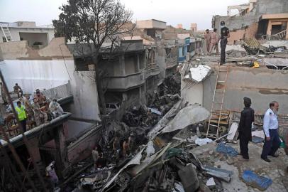  Security personnel search for victims in the wreckage of a Pakistan International Airlines aircraft after it crashed in a residential area in Karachi on May 22, 2020. - A Pakistani passenger plane with nearly 100 people on board crashed into a residential area of the southern city of Karachi on May 22. (Photo by Asif HASSAN / AFP)Editoria: DISLocal: KarachiIndexador: ASIF HASSANSecao: accident (general)Fonte: AFPFotógrafo: STF<!-- NICAID(14506068) -->