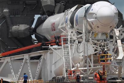 CAPE CANAVERAL, FLORIDA - MAY 26: Workers prepare the SpaceX Falcon 9 rocket with the Crew Dragon spacecraft attached for tomorrows scheduled liftoff from launch pad 39A at the Kennedy Space Center on May 26, 2020 in Cape Canaveral, Florida. NASA astronauts Bob Behnken and Doug Hurley will be aboard the May 27th inaugural flight and will be the first people since the end of the Space Shuttle program in 2011 to be launched into space from the United States.   Joe Raedle/Getty Images/AFP