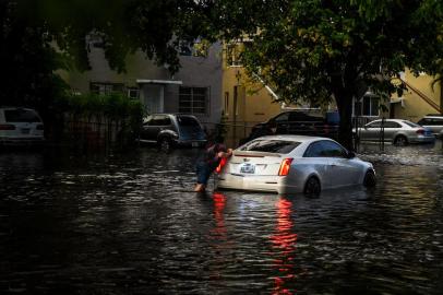  A man pushes a car after it broke down in floodwater during heavy rainfall in Miami, on May 26, 2020. - Residents of South Florida couldnt enjoy the recent reopening of restaurants, businesses, and beaches after almost two months of quarantine due to the pandemic: three days in a row of heavy rains, which reached 6 inches on May 26, caused severe floods in Miami and other coastal cities affected by rising sea levels. (Photo by CHANDAN KHANNA / AFP)Editoria: HTHLocal: MiamiIndexador: CHANDAN KHANNASecao: epidemic and plagueFonte: AFPFotógrafo: STF<!-- NICAID(14508881) -->