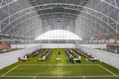 Students sit on May 26, 2020 at the Vallhall Sports Arena in Oslo, that is one of several places used as an examination room for many of the 8000 students doing their Spring 2020 Privatisteksamen exams. - There is more distance between the students and disinfectants are available. (Photo by Lise Åserud / NTB Scanpix / AFP) / Norway OUT<!-- NICAID(14508954) -->