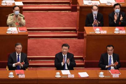 Chinas President Xi Jinping (C), Premier Li Keqiang (R) and Chairman of the Chinese Peoples Political Consultative Conference (CPPCC) Wang Yang (L) applaud after the vote on a proposal to draft a Hong Kong security law during the closing session of the National Peoples Congress at the Great Hall of the People in Beijing on May 28, 2020. - Chinas parliament approved plans on May 28 to impose a security law on Hong Kong that critics say will eradicate the citys promised freedoms. (Photo by NICOLAS ASFOURI / AFP)<!-- NICAID(14509745) -->