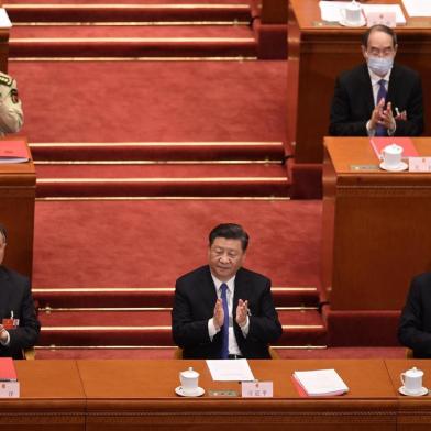 Chinas President Xi Jinping (C), Premier Li Keqiang (R) and Chairman of the Chinese Peoples Political Consultative Conference (CPPCC) Wang Yang (L) applaud after the vote on a proposal to draft a Hong Kong security law during the closing session of the National Peoples Congress at the Great Hall of the People in Beijing on May 28, 2020. - Chinas parliament approved plans on May 28 to impose a security law on Hong Kong that critics say will eradicate the citys promised freedoms. (Photo by NICOLAS ASFOURI / AFP)<!-- NICAID(14509745) -->