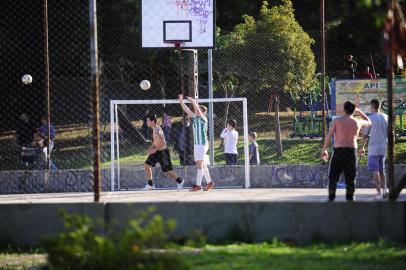  CAXIAS DO SUL, RS, BRASIL, 30/05/2020. Sem máscara e desrespeitando orientação de distanciamento, moradores frequentam praças e parques de Caxias. Medidas - Grupos jogavam vôlei e futebol, pessoas tomavam chimarrão e crianças brincavam na grama sem proteção no rosto na tarde deste sábado (30). Na foto, jovens em praça no bairro Cruzeiro. NA FOTO, PRAÇA NO SANTA LÚCIA COHAB. (Porthus Junior/Agência RBS)Indexador:                                 <!-- NICAID(14511659) -->