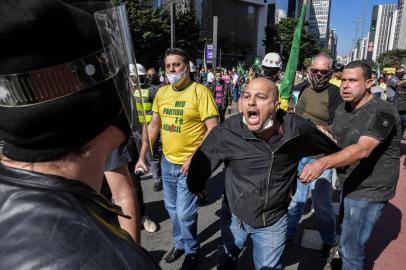  A supporter of Brazilian President Jair Bolsonaro (R) argues with an anti-Bolsonaro football fan during a protest against the president, at Paulista Avenue in Sao Paulo, Brazil, on May 31, 2020, amid the COVID-19 novel coronavirus pandemic. (Photo by Nelson ALMEIDA / AFP)Editoria: HTHLocal: Sao PauloIndexador: NELSON ALMEIDASecao: diseaseFonte: AFPFotógrafo: STF<!-- NICAID(14511882) -->