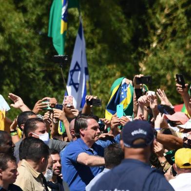 Brazilian President Jair Bolsonaro (C) greets supporters during a demonstration in Brasilia, on May 31, 2020 during the COVID-19 novel coronavirus pandemic. - Bolsonaro, who fears the economic fallout from stay-at-home orders will be worse than the virus, has berated governors and mayors for imposing what he calls the tyranny of total quarantine. Even as his country surpassed France to have the worlds fourth-highest death toll, Bolsonaro called for Brazils football season to resume. (Photo by EVARISTO SA / AFP)<!-- NICAID(14514156) -->