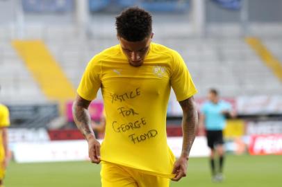  Dortmunds English midfielder Jadon Sancho shows a Justice for George Floyd shirt as he celebrates after scoring his teams second goal during the German first division Bundesliga football match SC Paderborn 07 and Borussia Dortmund at Benteler Arena in Paderborn on May 31, 2020. (Photo by Lars Baron / POOL / AFP) / DFL REGULATIONS PROHIBIT ANY USE OF PHOTOGRAPHS AS IMAGE SEQUENCES AND/OR QUASI-VIDEOEditoria: SPOLocal: PaderbornIndexador: LARS BARONSecao: soccerFonte: POOLFotógrafo: STR<!-- NICAID(14514388) -->