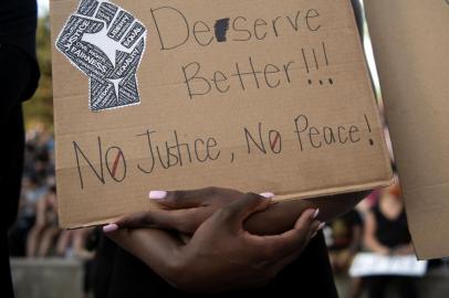 A demonstrator holds a sign at Civic Center Park in Denver, Colorado on June 3, 2020, while protesting the death of George Floyd, an unarmed black man who died while while being arrested and pinned to the ground by the knee of a Minneapolis police officer - US protesters welcomed new charges brought Wednesday against Minneapolis officers in the killing of African American man George Floyd -- but thousands still marched in cities across the country for a ninth straight night, chanting against racism and police brutality. (Photo by Jason Connolly / AFP)