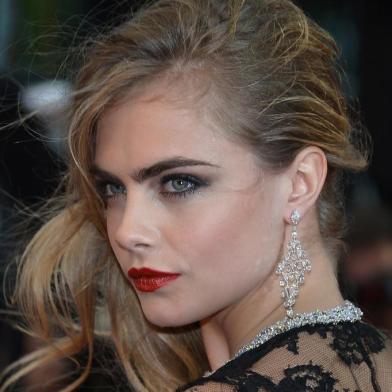 British model Cara Delevingne poses on May 15, 2013 as she arrives for the screening of The Great Gatsby ahead of the opening of the 66th edition of the Cannes Film Festival in Cannes. Cannes, one of the worlds top film festivals, opens on May 15 and will climax on May 26 with awards selected by a jury headed this year by Hollywood legend Steven Spielberg.      AFP PHOTO / ALBERTO PIZZOLI<!-- NICAID(9382412) -->