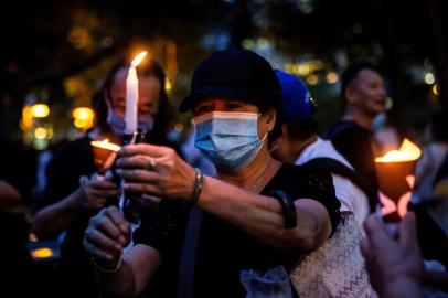 Activists light candles during a remembrance gathering outside Victoria Park in Hong Kong on June 4, 2020, after an annual vigil that traditionally takes place in the park to mark the 1989 Tiananmen Square crackdown was banned on public health grounds because of the COVID-19 coronavirus pandemic. (Photo by ISAAC LAWRENCE / AFP)<!-- NICAID(14515110) -->