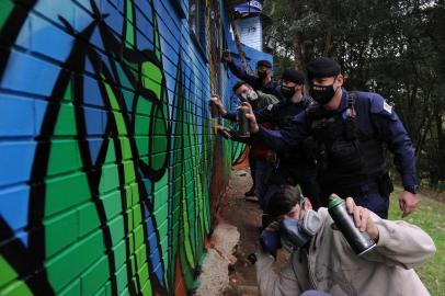  CAXIAS DO SUL, RS, BRASIL, 04/06/2020 - O artista Fabio Panone colabora na pintura de um painel na nova sede da Guarda Municipal. O grafite do artista poderá ser visto numa casinha situada no segundo estacionamento da prefeitura, restaurada pelos servidores, responsáveis pelo setor de Ronda Ostensiva Municipal - ROMU. (Marcelo Casagrande/Agência RBS)<!-- NICAID(14515182) -->