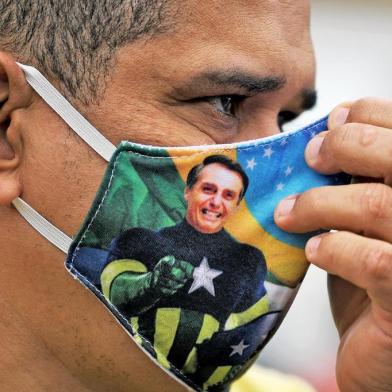  A supporter of President Jair Bolsonaro wears a face mask with Bolsonaros image during a demonstration at Copacabana beach in Rio de Janeiro, Brazil, on June 7, 2020. (Photo by CARL DE SOUZA / AFP)Editoria: POLLocal: BrasíliaIndexador: CARL DE SOUZASecao: demonstrationFonte: AFPFotógrafo: STF<!-- NICAID(14517188) -->