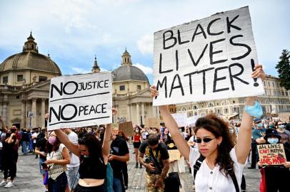 Protesters hold  placards during a rally in solidarity with the Black Lives Matter movement on the Piazza del Popolo in Rome, on June 7, 2020, as part of a weekend of protests worldwide against racism and police brutality, in the wake of the death of George Floyd, an unarmed black man killed while apprehended by police in Minneapolis, US. (Photo by Alberto PIZZOLI / AFP)<!-- NICAID(14517286) -->