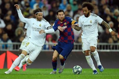 Barcelona's Argentine forward Lionel Messi is flanked by Real Madrid's Spanish defender Sergio Ramos (L) and Real Madrid's Brazilian defender Marcelo during the Spanish League football match between Real Madrid and Barcelona at the Santiago Bernabeu stadium in Madrid on March 1, 2020. (Photo by OSCAR DEL POZO / AFP)<!-- NICAID(14487921) -->