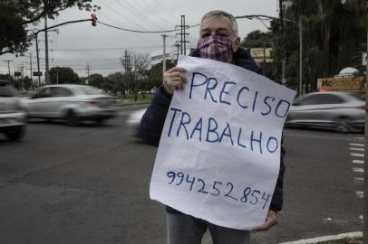  PORTO ALEGRE, RS, BRASIL - Senhor de 68 anos segura uma placa na rua pedindo trabalhoAssunto da Pauta: Senhor Carlos Ramiro da Silva, 67 anos, casado, foi um dos tantos que em Março, quando estourou a pandemia, ficou sem trabalho. Seu último emprego foi de auxiliar de oficina mecânica. Hoje, ele busca uma oportunidade, fixa ou não, para poder trabalhar e levar sustento para sua casa, já que, segundo ele, com a aposentadoria que ganha, se a pandemia durar mais um pouco, não conseguirá pagar seu aluguel.Indexador: Jefferson Botega