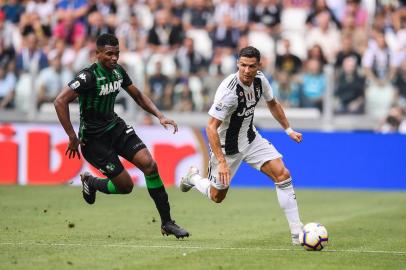  Juventus Portuguese forward Cristiano Ronaldo (r) outruns Sassuolos defender Marlon Santos during the Italian Serie A football match Juventus vs Sassuolo on September 16, 2018 at the Juventus stadium in Turin. / AFP PHOTO / Marco BERTORELLOEditoria: SPOLocal: TurinIndexador: MARCO BERTORELLOSecao: soccerFonte: AFPFotógrafo: STF<!-- NICAID(13743849) -->