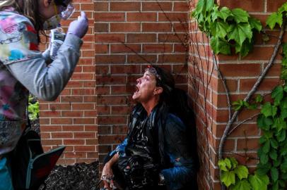 Black lives matter protestA medic protestor assists a member of the media after police started firing tear gas and rubber bullets near the 5th police precinct during a demonstration to call for justice for George Floyd, a black man who died while in custody of the Minneapolis police, on May 30, 2020 in Minneapolis, Minnesota. - Curfews were imposed in major US cities Saturday as clashes over police brutality escalated across America with demonstrators ignoring warnings from President Donald Trump that his government would stop the violent protests cold. (Photo by CHANDAN KHANNA / AFP)Editoria: POLLocal: MinneapolisIndexador: CHANDAN KHANNASecao: racismFonte: AFPFotógrafo: STF<!-- NICAID(14521222) -->