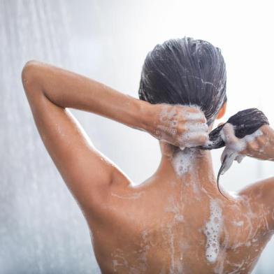 Woman using shampoo during taking showerSenhora lavando o cabelo enquanto relaxa sob a corrente de água. Ela gesticulando as mãosFonte: 213497563<!-- NICAID(14325170) -->