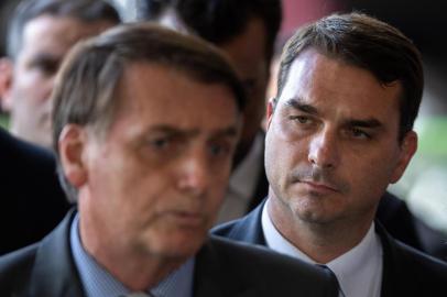  (FILES) In this file photo taken on November 28, 2018, The president-elect of Brazil, Jair Bolsonaro (L) and his son Flavio Bolsonaro (R), arrive for a press conference on the appointment of the ministers of Citizenship, Tourism and Regional Development at the headquarters of the transitional government in Brasilia on November 28, 2018. - The eldest son of Brazilian President Jair Bolsonaro has denied accusations he laundered money through real estate deals, months after the eruption of a suspicious payments scandal involving him that tarnished his father's anti-corruption credentials. (Photo by Sergio LIMA / AFP)Editoria: POLLocal: BrasíliaIndexador: SERGIO LIMASecao: corporate crimeFonte: AFPFotógrafo: STR<!-- NICAID(14081395) -->