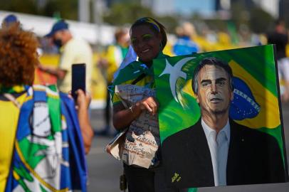  A woman poses for a snapshot holding a portrait of Brazilian President Jair Bolsonaro during a demonstration in his support in Brasilia, Brazil, on June 21, 2020, amid the COVID-19 pandemic. - Since the start of the pandemic, Bolsonaro has been clashing with state and local authorities over their use of stay-at-home measures and business closures to contain it. Brazil is Latin Americas worst-hit country with 49,976 deaths from 1,067,579 cases. (Photo by Sergio LIMA / AFP)Editoria: POLLocal: BrasíliaIndexador: SERGIO LIMASecao: citizens initiative and recallFonte: AFPFotógrafo: STR<!-- NICAID(14527509) -->