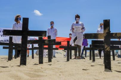 ManifestaÃ§Ã£o dos profissionais da saÃºde em Fortaleza Fortaleza (CE), 21/06/2020 - Ato de MÃ©dicos - Profissionais da saÃºde realizam ato em defesa da vida, da democracia e da manutenÃ§Ã£o do Sistema Ãnico de SaÃºde (SUS) durante a manhÃ£ deste domingo, 21, no Aterro da Praia de Iracema, em Fortaleza. Cinquenta cruzes foram colocadas na areia simbolizando as mais de 50 mil vÃ­timas da Covid-19 (Foto: Mateus Dantas/Zimel Press/Folhapress) Local: Fortaleza ;CearÃ¡ ;Brasil<!-- NICAID(14527576) -->