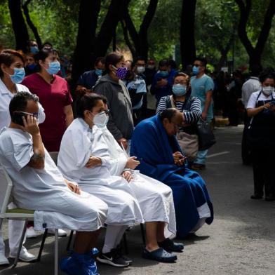  People remain outside the Durango clinic in Mexico City during a quake on June 23, 2020 amid the COVID-19 novel coronavirus pandemic. - A 7.1 magnitude quake was registered Tuesday in the south of Mexico, according to the Mexican National Seismological Service. (Photo by CLAUDIO CRUZ / AFP)Editoria: DISLocal: Mexico CityIndexador: CLAUDIO CRUZSecao: diseaseFonte: AFPFotógrafo: STR<!-- NICAID(14529029) -->