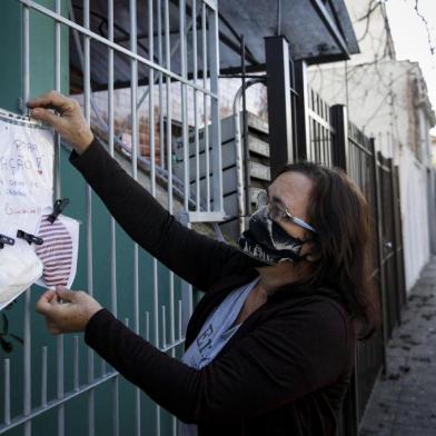  PORTO ALEGRE, RS, BRASIL, 23-06-2020: A cuidadora de idosos, Vilma Freitas dos Santos, 61 anos, doa máscaras que ela mesma produz no portao do prédio onde mora, na rua Sebastião Leão. Ela fixa um cartaz na grade do edifício e disponibiliza mascaras ja higienizadas em saquinhos para quem precisa. (Foto: Mateus Bruxel / Agencia RBS)Indexador: Mateus Bruxel