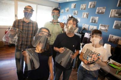  PORTO ALEGRE, RS, BRASIL - A empresa Print Up 3D está montando e doando face shields para hospitais. Na foto: Amanda Pires (azul), Marcelo Kratz (camiseta xadrez) , Leonardo Murillo (menino menor), Leonardo Kratz (camisa verde) e Júlia Longhi (camiseta MTV). (Foto: Jefferson Botega/Agencia RBS)Indexador: Jefferson Botega<!-- NICAID(14529106) -->