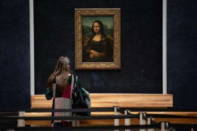  A picture taken on June 23, 2020 shows a woman in front of Italian artist Leonardo da Vincis Mona Lisa at the Louvre in Paris, during a press visit of the museum. - The Louvre museum will reopen its doors on July 6, 2020, after months of closure due to lockdown measures linked to the COVID-19 pandemic, caused by the novel coronavirus. The coronavirus crisis has already caused more than 40 million euros in losses at the Louvre, announced its president and director Jean-Luc Martinez, who advocates a revival through cultural democratization and is preparing a transformation plan for the upcoming Olympic Games in 2024. (Photo by THOMAS SAMSON / AFP)Editoria: ACELocal: ParisIndexador: THOMAS SAMSONSecao: library and museumFonte: AFPFotógrafo: STF<!-- NICAID(14530738) -->
