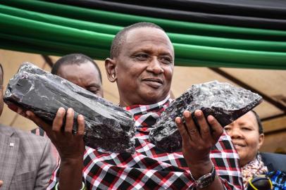 Tanzanian small-scale miner Saniniu Kuryan Laizer, 52, poses with two of the biggest of the countrys precious gemstones, Tanzanite, as a millionaire during the ceremony for his historical discovery in Manyara, northern Tanzania, on June 24, 2020. - Laizer found the stones weighing 9.27 and 5.1 kilogrammes respectively in the northern Mirerani hills, an area which President John Magufuli had fenced off in 2018 to stop smuggling of the gem. He sold them to the government for 7.7 billion Tanzanian shillings (nearly $3.3 million/2.9 million euros). The broken biggest record of Tanzanite was 3.5 kilogrammes. (Photo by Filbert RWEYEMAMU / AFP)<!-- NICAID(14530853) -->