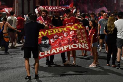 Fans celebrate Liverpool winning the Premier League title outside Anfield stadium in Liverpool, north west England on June 25, 2020, following Chelseas 2-1 victory over Manchester City. - Liverpool were crowned Premier League champions without kicking a ball on Thursday as Chelseas 2-1 win over Manchester City ended the Reds 30-year wait to win the English title. Jurgen Klopps men sealed a 19th league title for the club with a record seven games left to play after Citys defeat left them 23 points adrift of Liverpool at the top. (Photo by Paul ELLIS / AFP)<!-- NICAID(14531665) -->