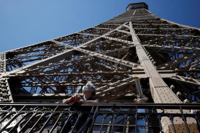  A visitor wearing a protective facemask admires the view from the Eiffel Tower during its partial reopening on June 25, 2020, in Paris, as France eases lockdown measures taken to curb the spread of the COVID-19 caused by the novel coronavirus. - Tourists and Parisians will again be able to admire the view of the French capital from the Eiffel Tower after a three-month closure due to the coronavirus -- but only if they take the stairs. (Photo by Thomas SAMSON / AFP)Editoria: ACELocal: ParisIndexador: THOMAS SAMSONSecao: diseaseFonte: AFPFotógrafo: STF<!-- NICAID(14530697) -->