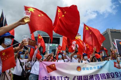  Pro-China supporters display Chinese and Hong Kong flags as they raise a toast with champagne during a rally near the government headquarters in Hong Kong on June 30, 2020, as China passed a sweeping national security law for the city. - China passed a sweeping national security law for Hong Kong, a historic move that critics and many western governments fear will smother the finance hubs freedoms and hollow out its autonomy. (Photo by Anthony WALLACE / AFP)Editoria: POLLocal: Hong KongIndexador: ANTHONY WALLACESecao: politics (general)Fonte: AFPFotógrafo: STF<!-- NICAID(14534003) -->